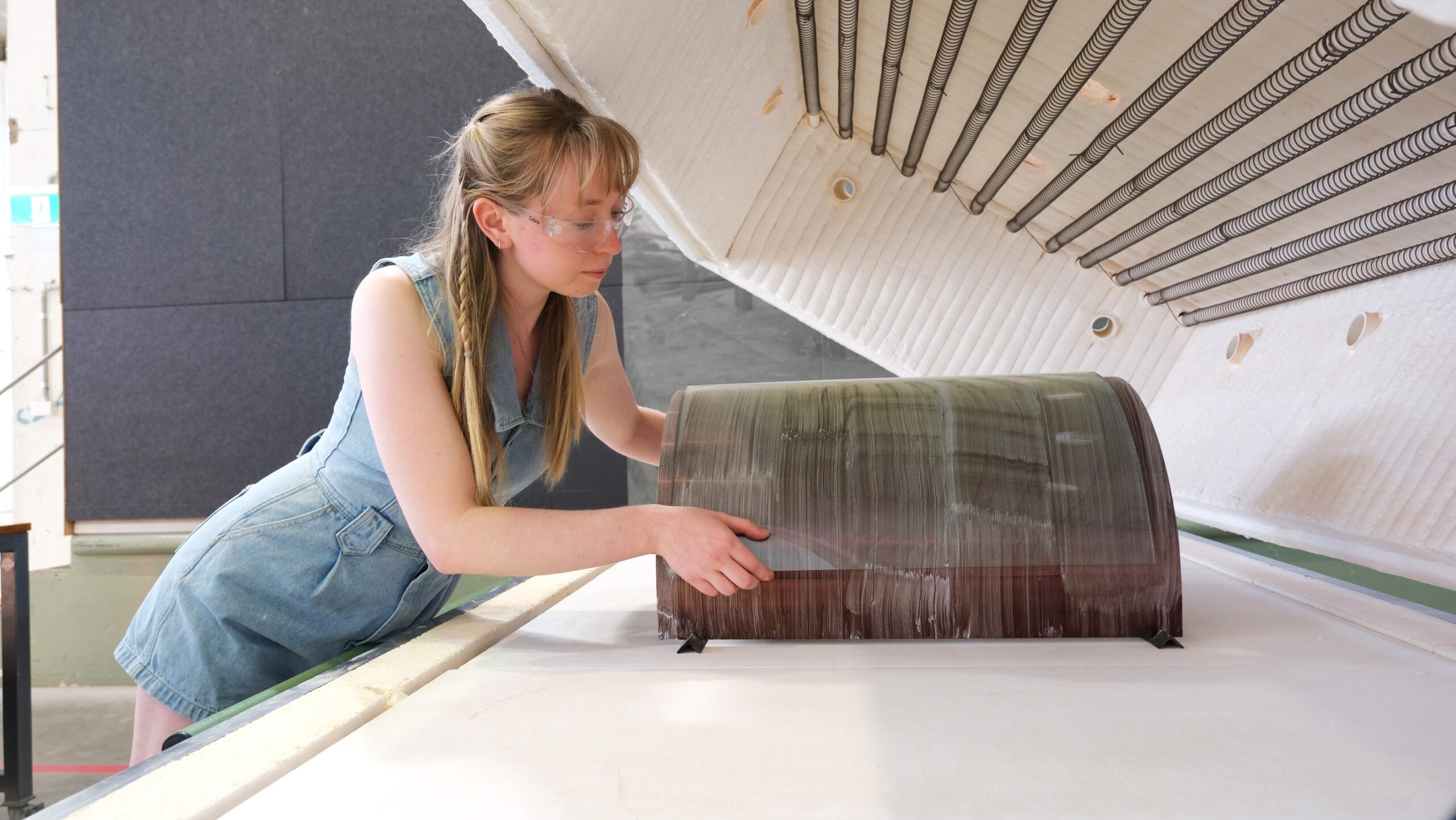 Artist, Bronte Cormican-Jones, removing glass sheet from kiln