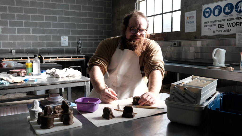 Artist, Cam Michael, carving wax in the Mould Room at Canberra Glassworks