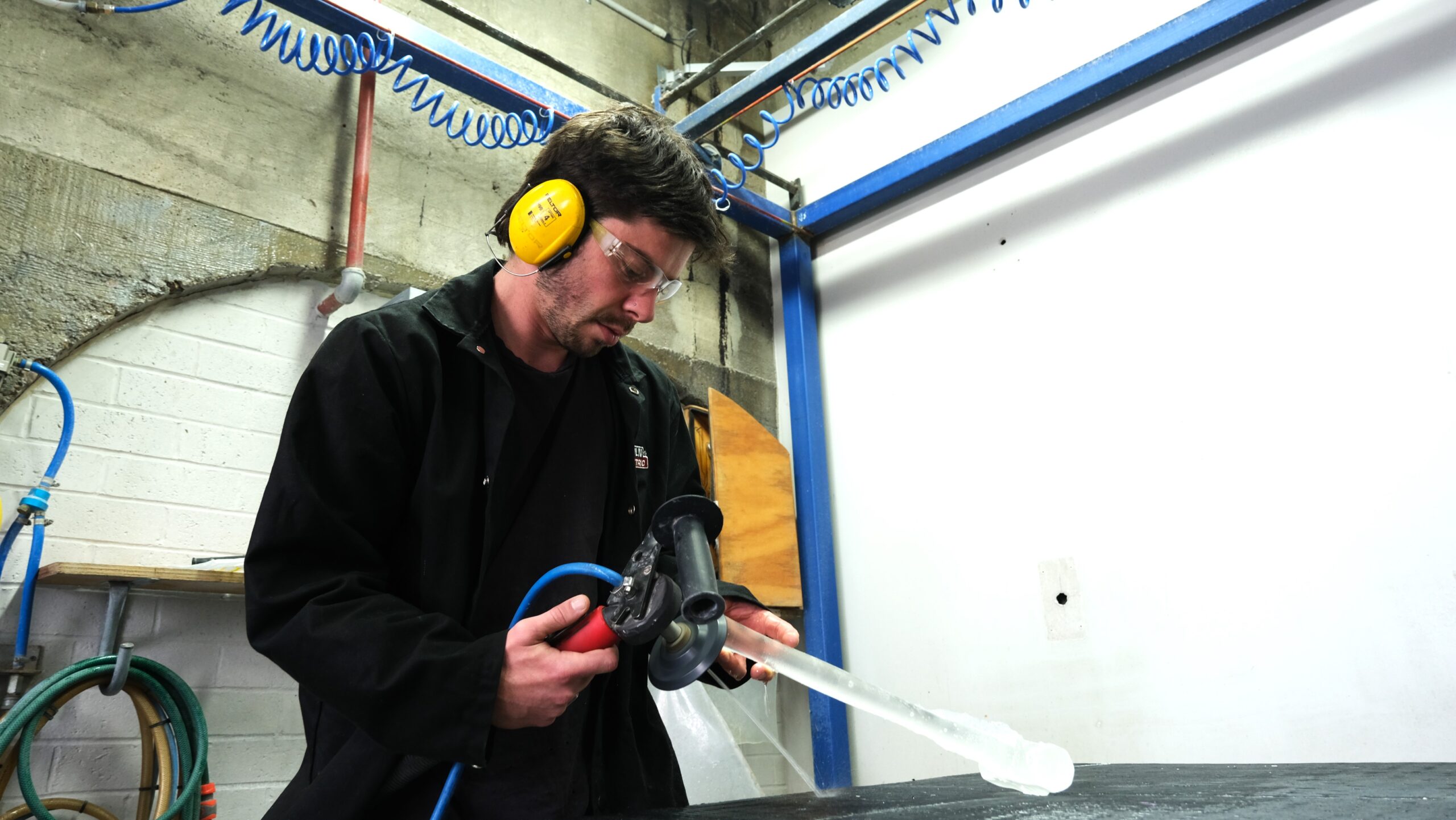 Artist, Nick Burridge, polishing glass work in the Coldshop at Canberra Glassworks