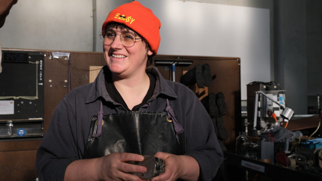 Artist, Emily Parsons-Lord, standing in the coldshhop at Canberra Glassworks